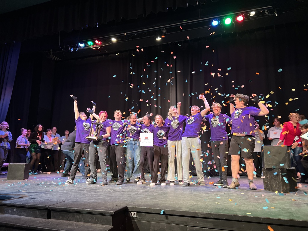 PIctured are CCVI students on stage with a trophy and confetti