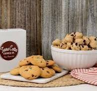 Terra Cotta Cookie Co white box with brown, circle label and a bowl of frozen cookie balls, and a napkin of baked cookies.