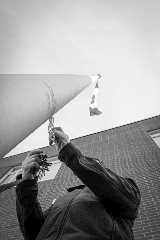 An ant-eye image of a person raising a flag on a flagpole