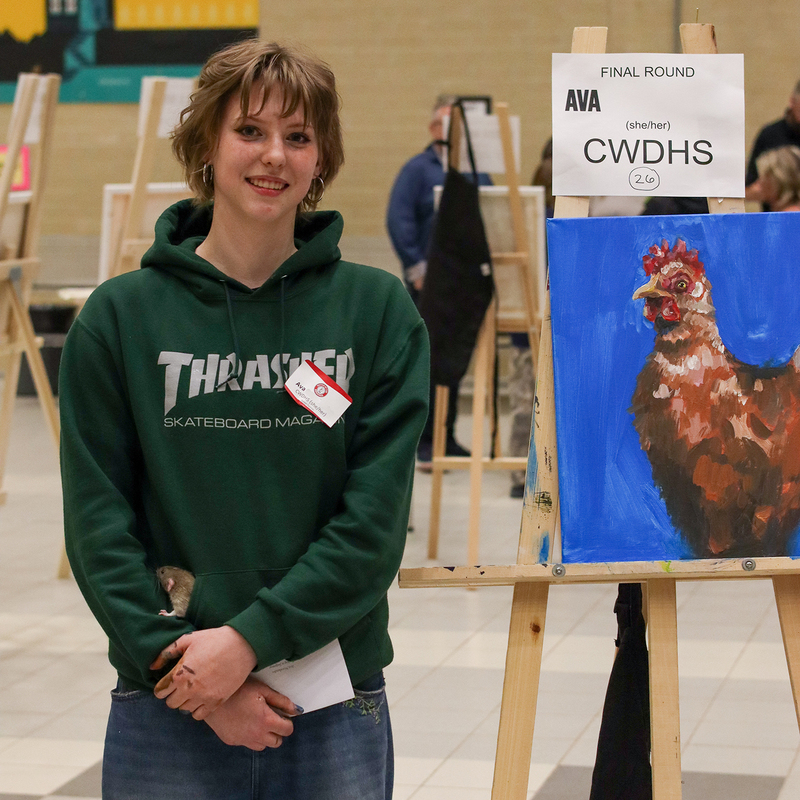 A student stands next to an aisle with a paint on it.