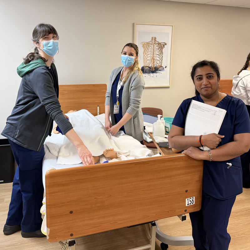 PSW students pose for a photo in a healthcare setting.