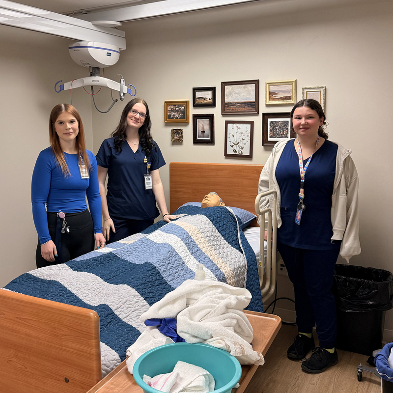 PSW students pose for a photo in a healthcare setting.