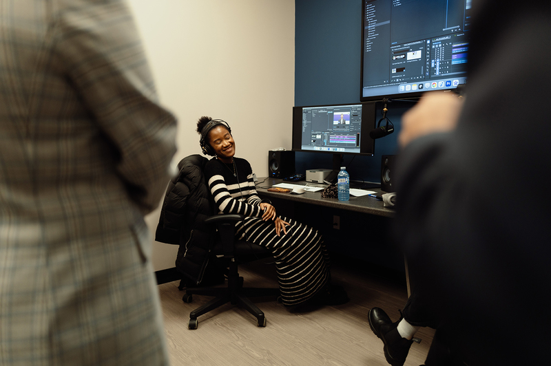 A co-op student sits at a computer editing station.