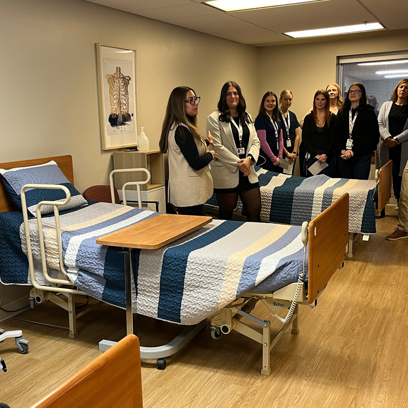 People stand inside a long-term care facility.
