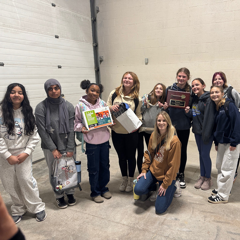 Students hold a plaque