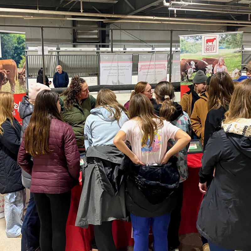 Students stand around a table looking at a presentation
